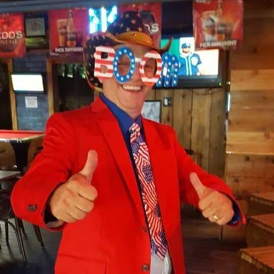 Two people behind a display counter in a market with various products.