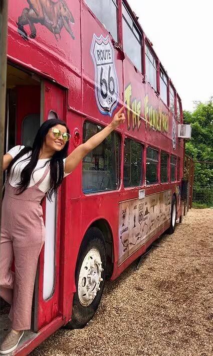 A colorful statue of a cartoonish hot dog character holding a drink.