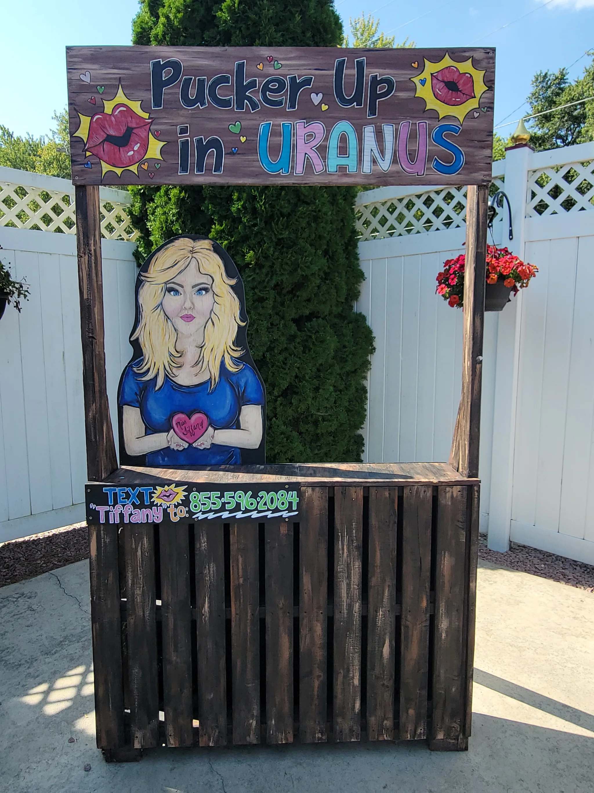 A wooden booth with a cartoon woman and colorful signage.