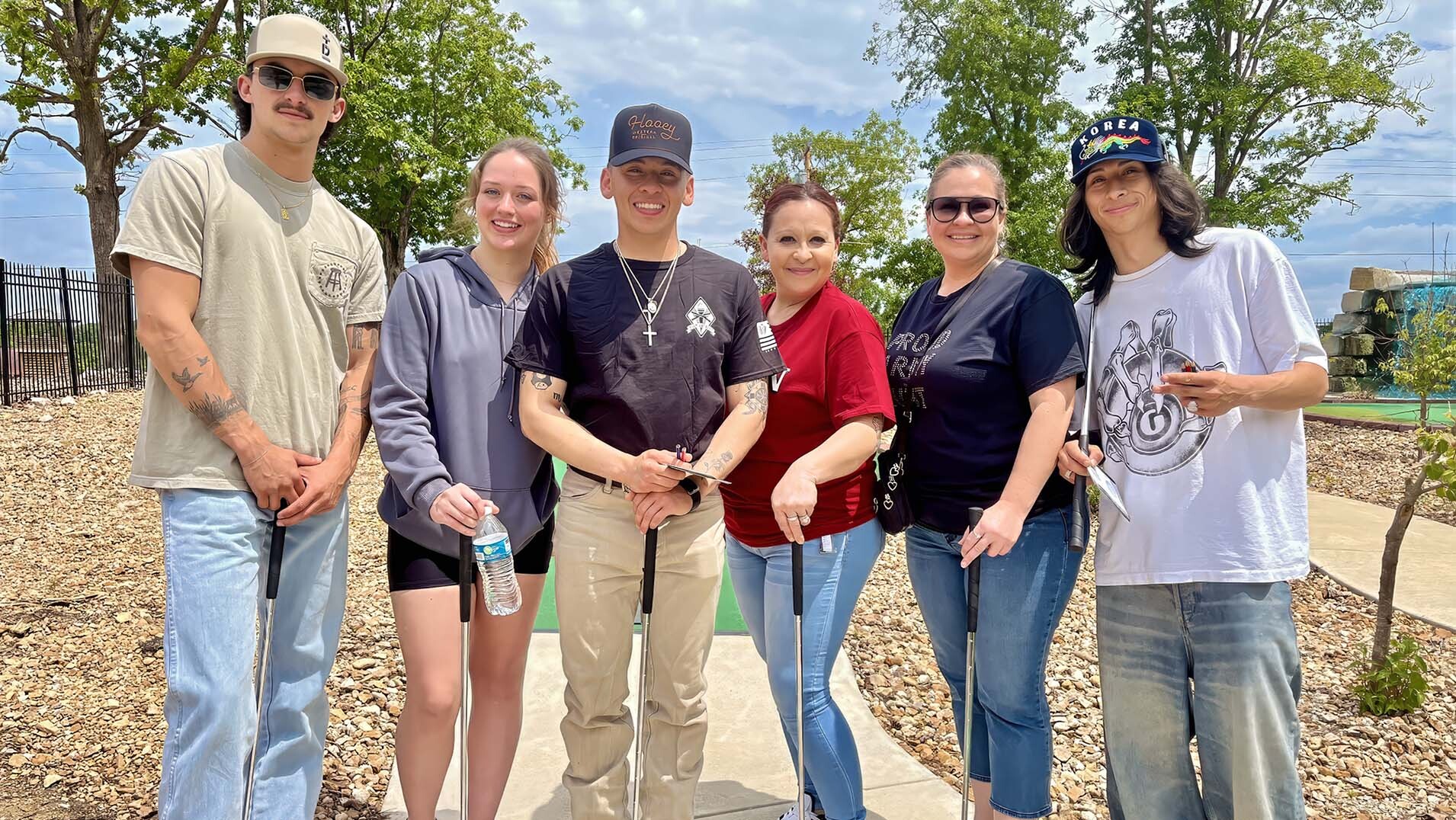 Group of visitors holding putters at the Putt Pirates mini golf course at Uranus in St. Robert, Missouri