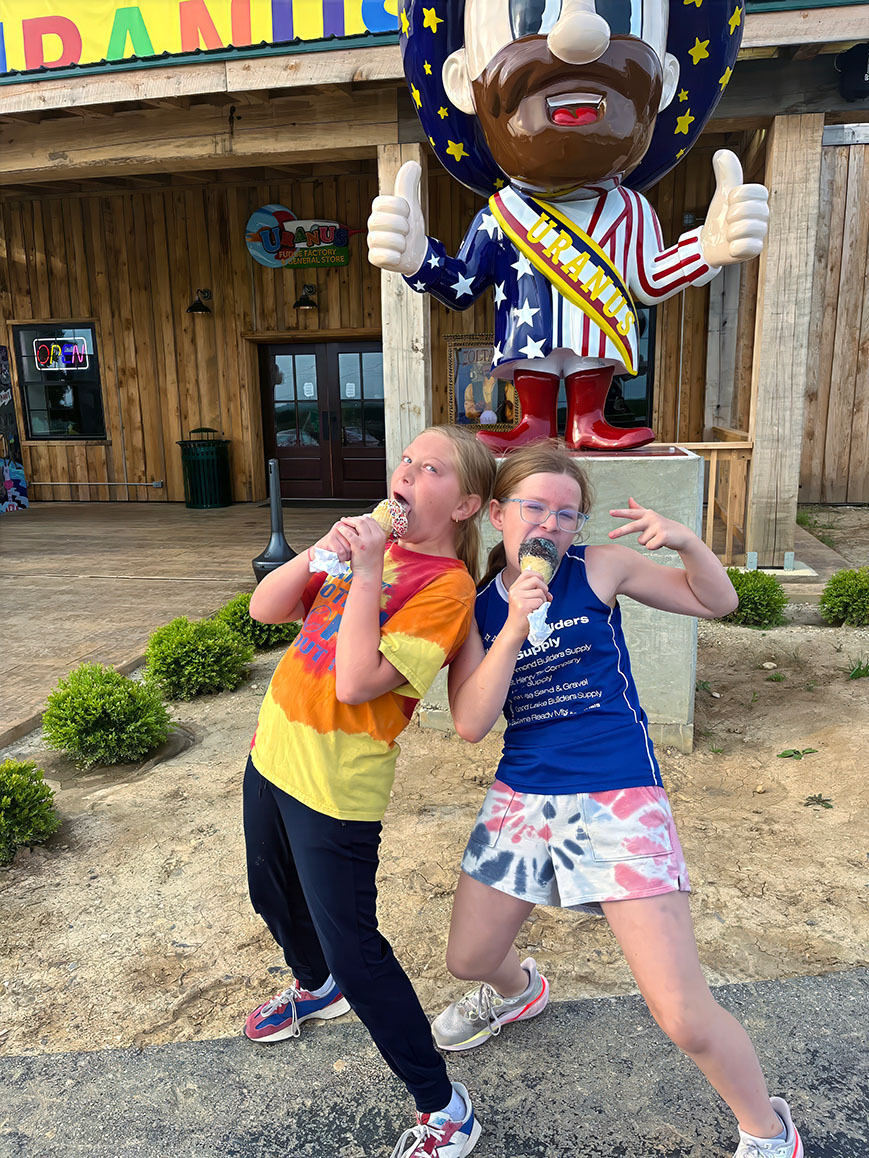 Two girls posing with ice cream cones outside the Uranus Ice Cream Co. in Richmond, Indiana