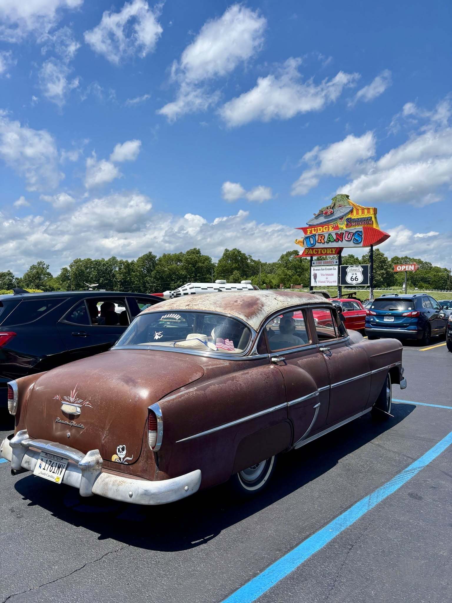 Patina 1954 Chevrolet from the 2026 HOT ROD Power Tour parked in front of the Uranus Fudge Factory and Sideshow Museum sign on Route 66