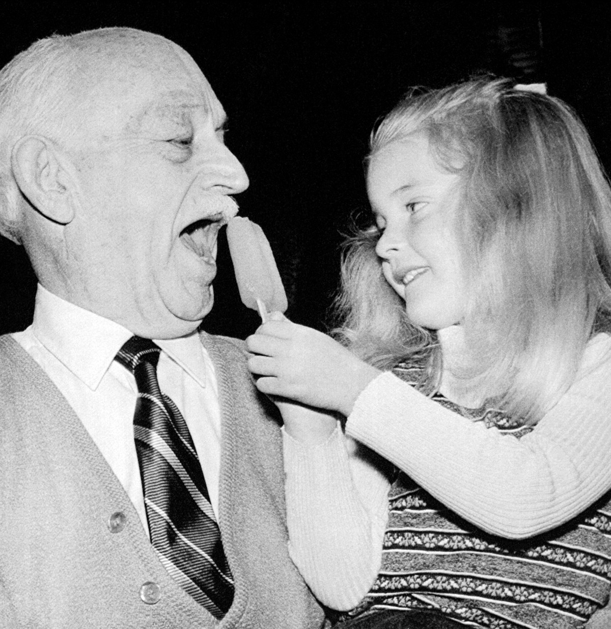 A man and a young girl share a Popsicle in 1973