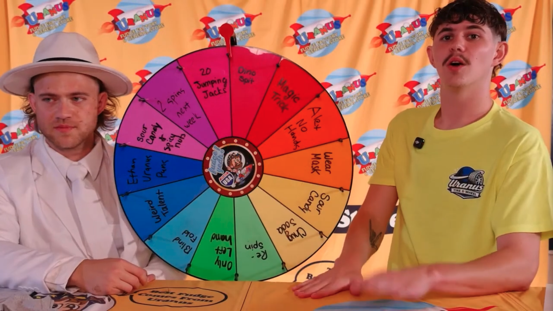 Alex Bradford Cobb and Ethan Bain stand next to the Wheel for Spin the Wheel on Uranus Live!